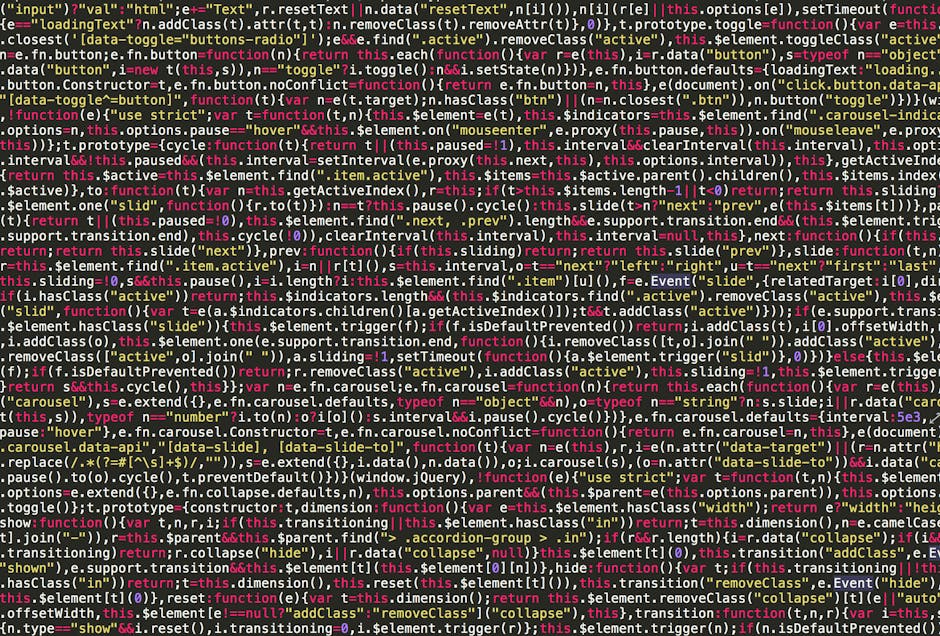 A close-up view of a computer screen displaying lines of programming code in various colors, including green, blue, purple, and white, on a dark background. To the left side of the screen, there is a